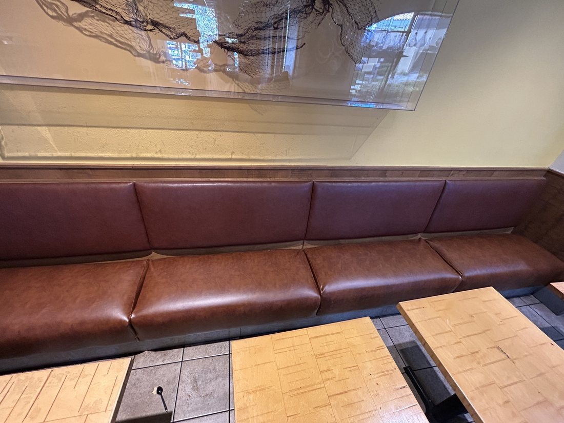The same Rubio's Coastal Grill wall banquette after reupholstery in saddle-brown commercial-grade vinyl, San Diego