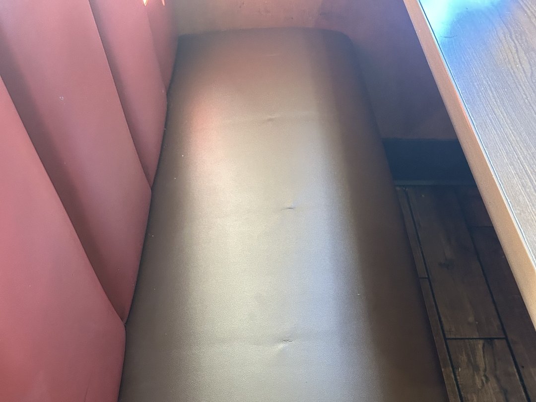Rebuilt Denny's booth seat cushion reupholstered in dark bronze commercial vinyl with tight double-stitched seams, San Diego